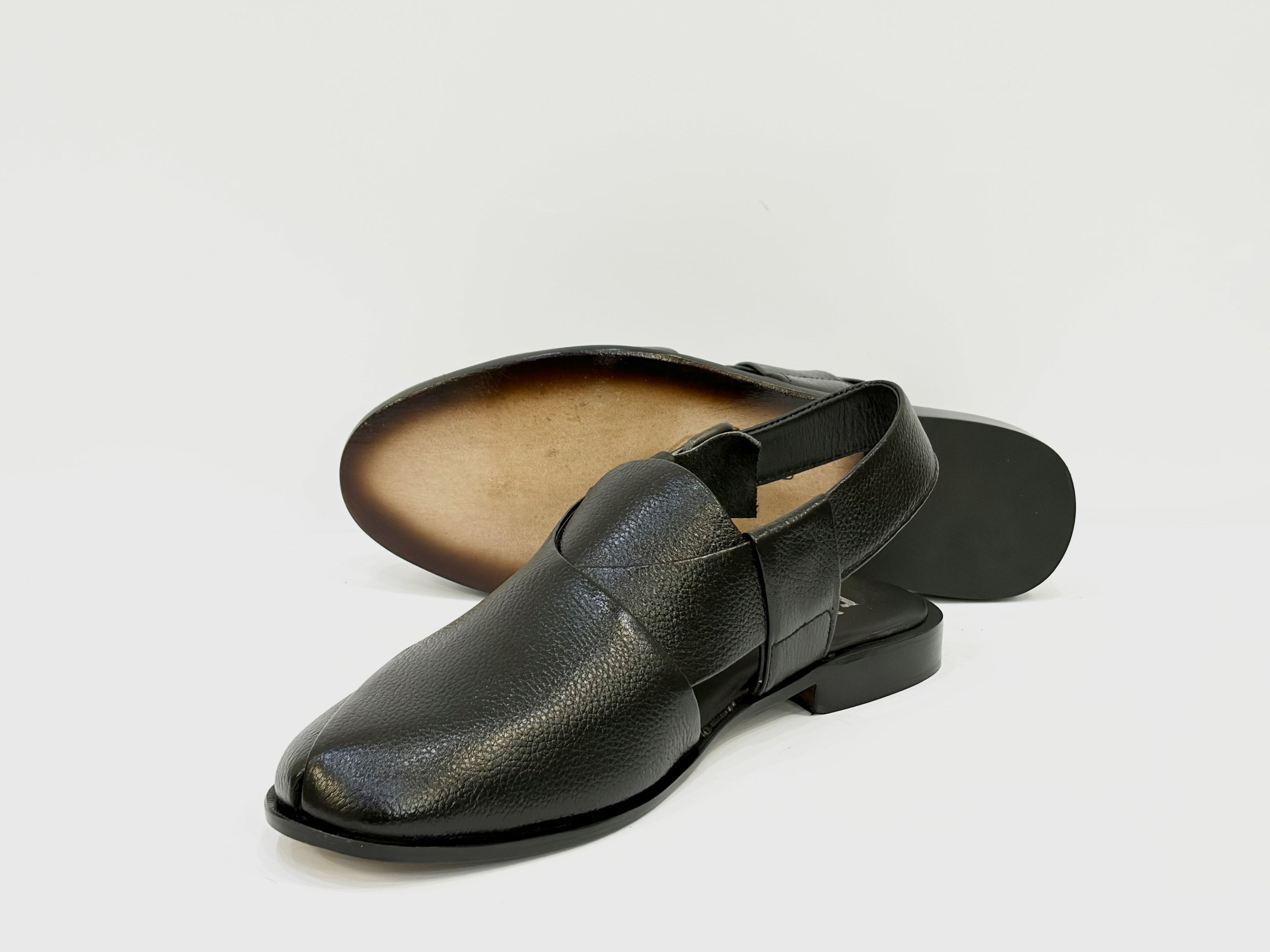 Black leather sandal with a textured finish on a light gray background