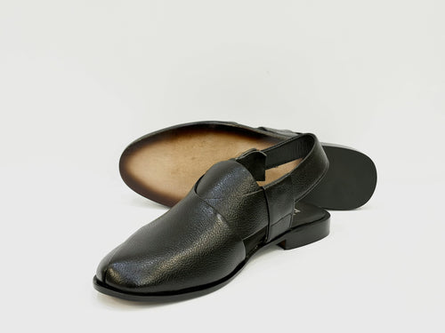 Black leather sandal with a textured finish on a light gray background